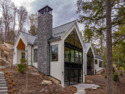 A contemporary home featuring elegant stone steps that lead up to its entrance, surrounded by a well-maintained landscape.