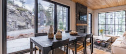 A contemporary living room featuring a cozy fireplace and expansive windows allowing natural light to fill the space.