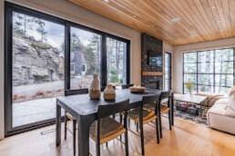 A contemporary living room featuring a cozy fireplace and expansive windows allowing natural light to fill the space.