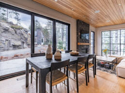 A contemporary living room featuring a cozy fireplace and expansive windows allowing natural light to fill the space.