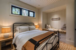 A cozy bedroom featuring a bed, a nightstand, and a window allowing natural light to enter the space.