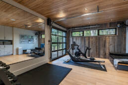 A well-equipped home gym featuring a large mirror and various exercise equipment for fitness enthusiasts.