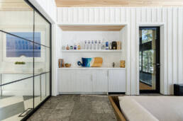 A contemporary home featuring a stylish bar with glass walls, blending elegance and modern design seamlessly.