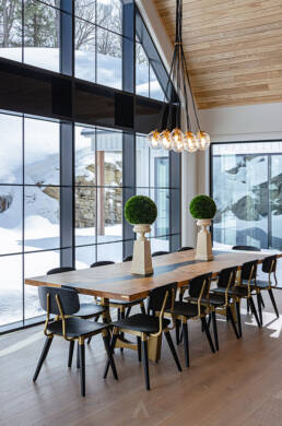A bright dining room with a large window and an elegant live edge table, creating a warm and inviting atmosphere.